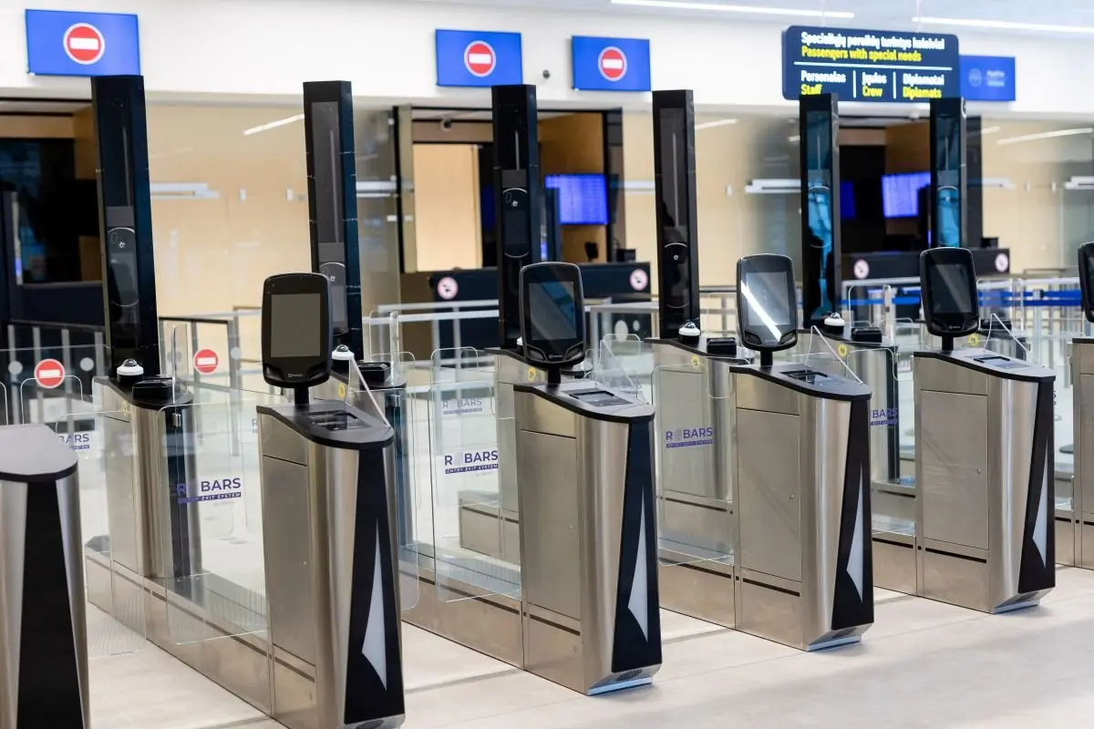 Security gates at Vilnius Airport with direction screens above the lanes